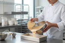 Chef transferring batter with bowl scraper